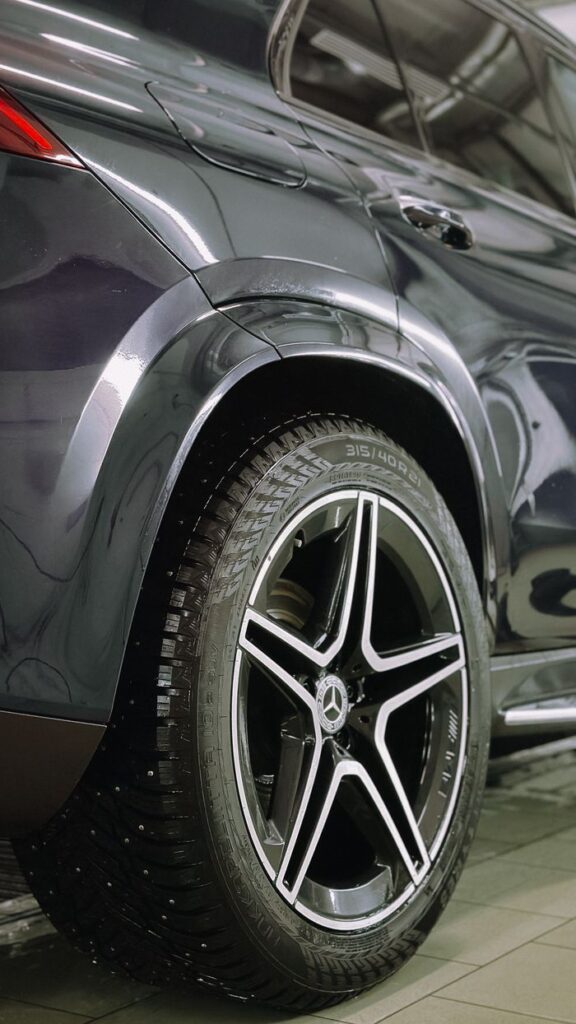 Detailed shot of a luxury car's wheel, showcasing tire design and alloy rim.